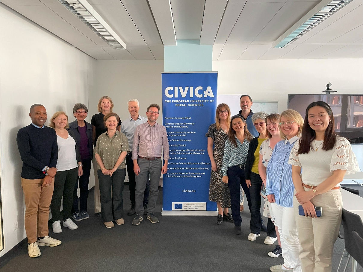 <i>The CIVICA Library Steering Committee meeting in Berlin in May 2025. Image: CIVICA</i> Group of 14 people in a room, in front of a blue banner that reads 'CIVICA THE EUROPEAN UNIVERSITY OF SOCIAL SCIENCES'.